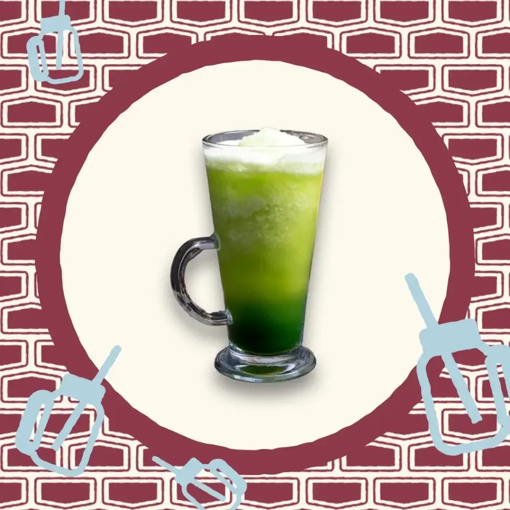 Smoothie vert clair dans un verre à pied avec une mousse blanche