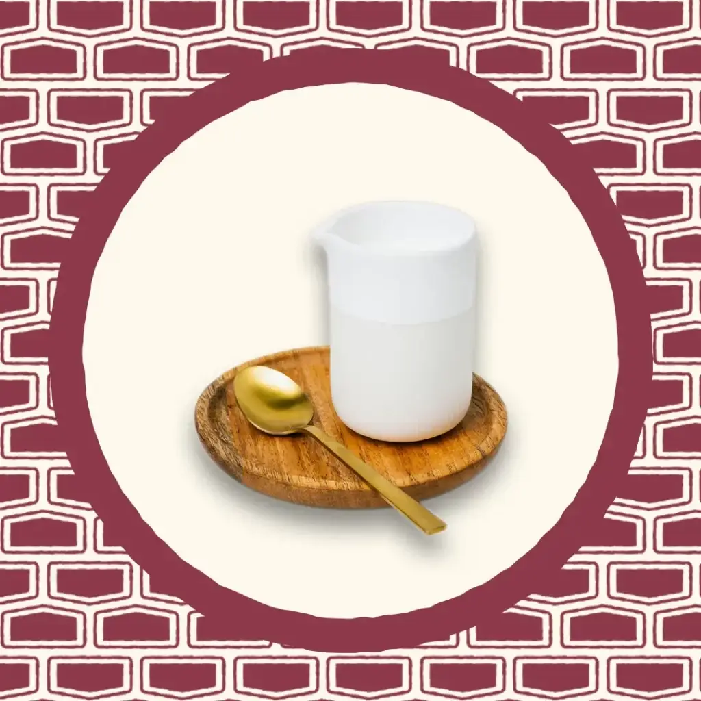 Pot de lait avec cuillère en bois et fond clair